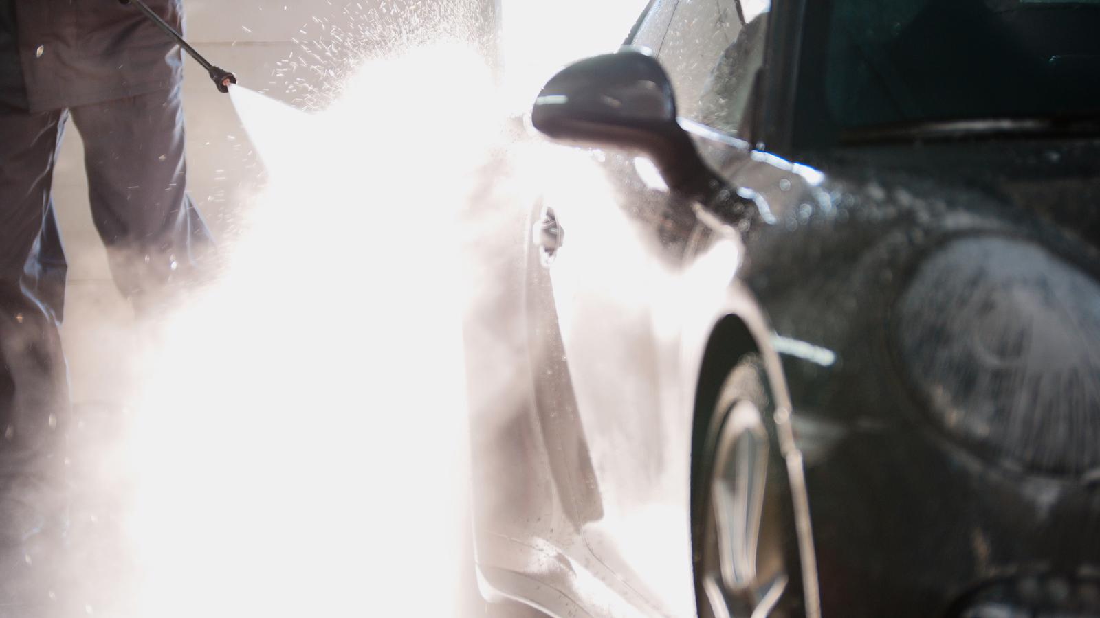 40236640-mechanic-in-car-service-is-washing-sport-car-in-the-suds-by-water-hoses-backlight